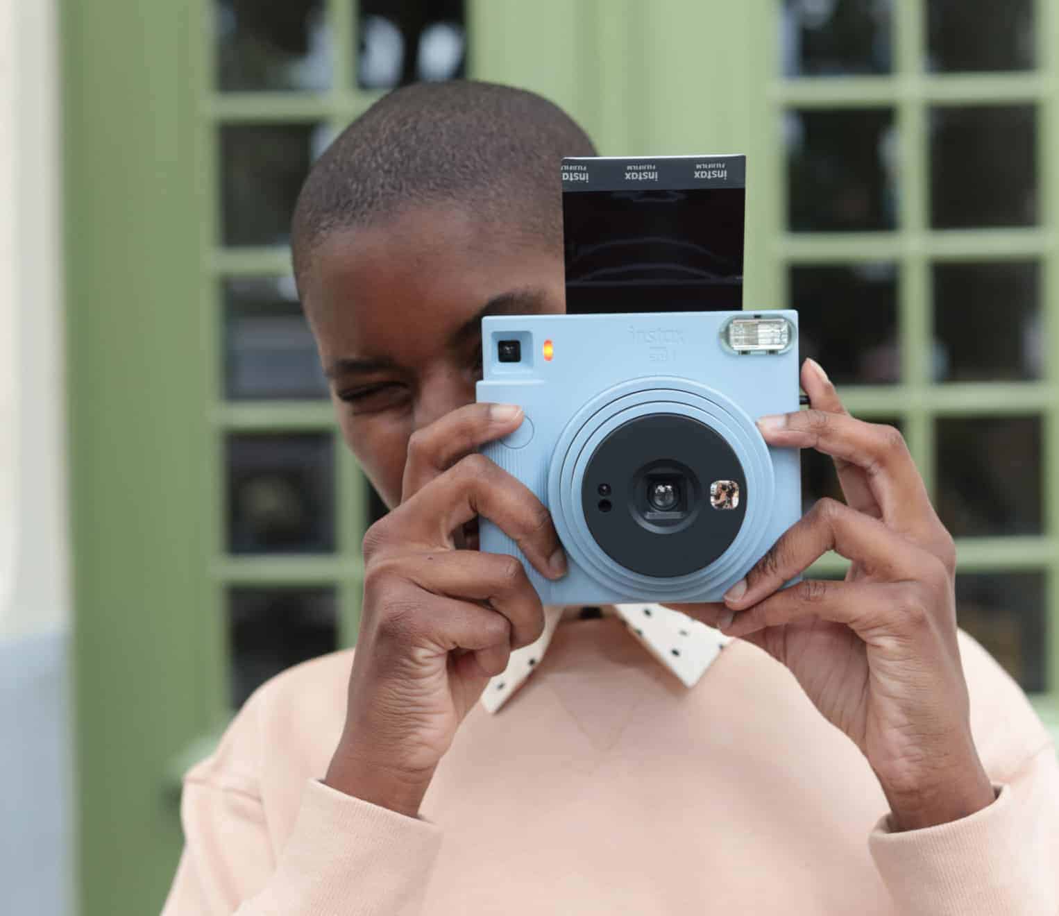 person taking photo with instax camera