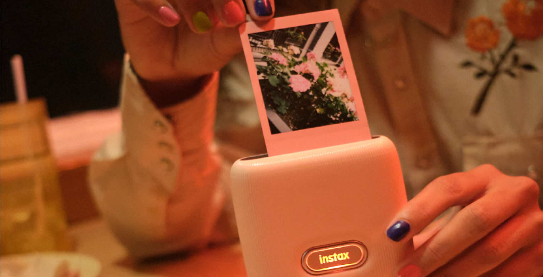 instax printer with person removing photo