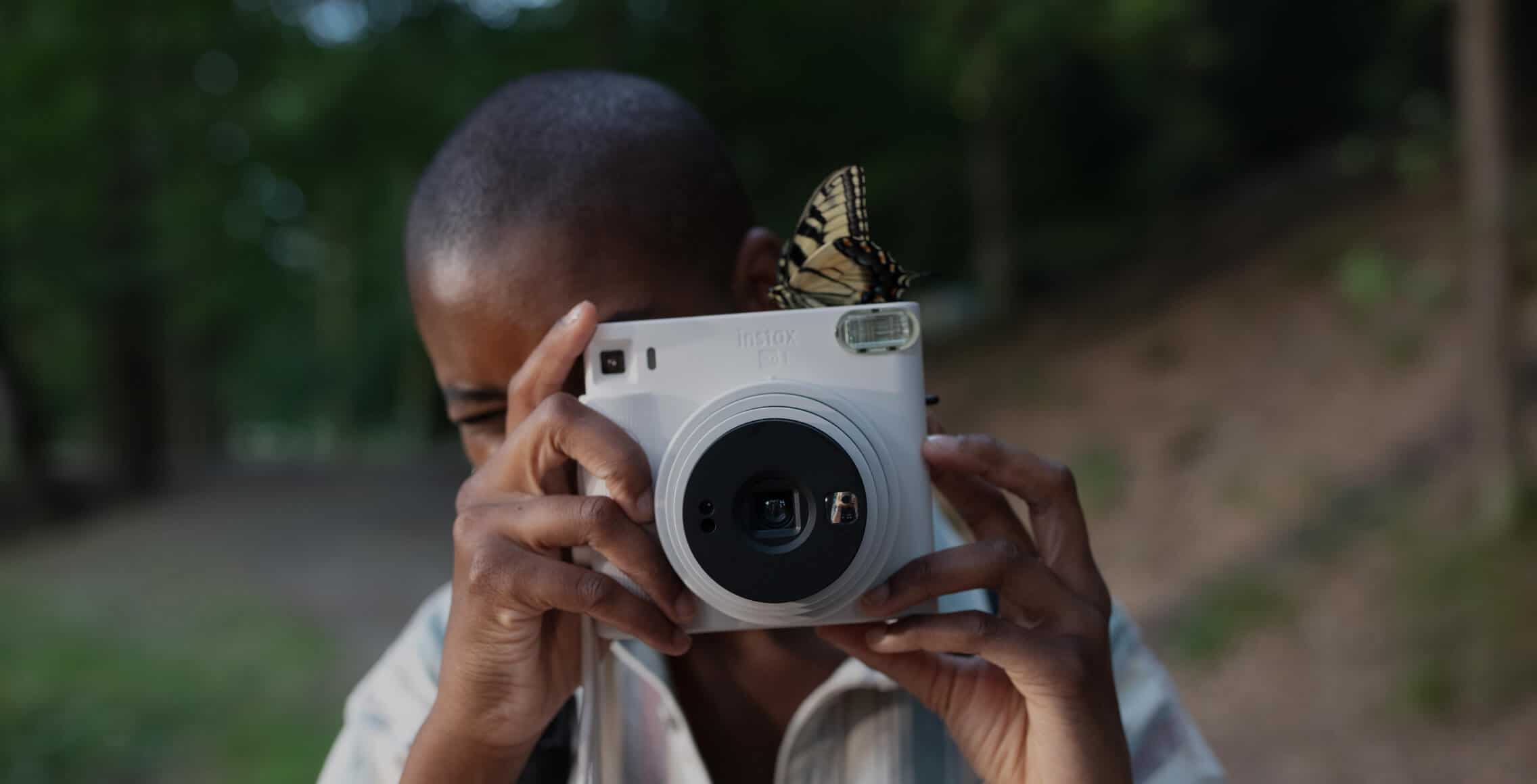 person taking a picture with instax square camera